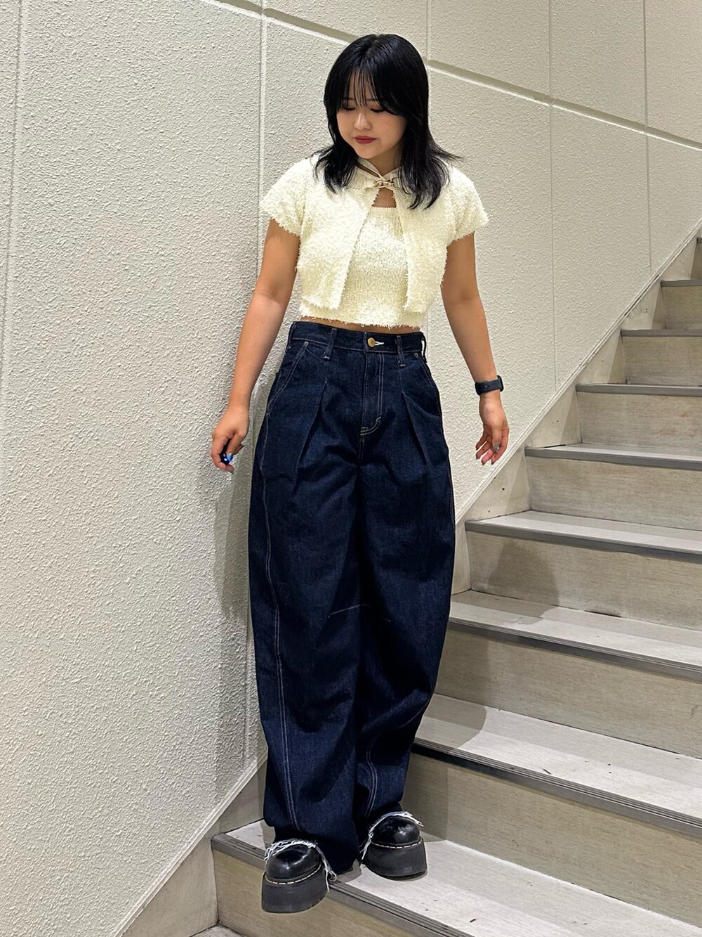 ブラック系のアンサンブル、ブルー系のデニムパンツを着用したレディースの夏コーディネートの2枚目の写真