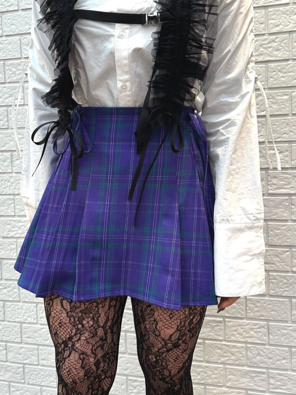 パープル系のスカート、ホワイト系のシャツ/ブラウス、ブラック系のサスペンダーを着用したレディースの冬コーディネートの5枚目の写真