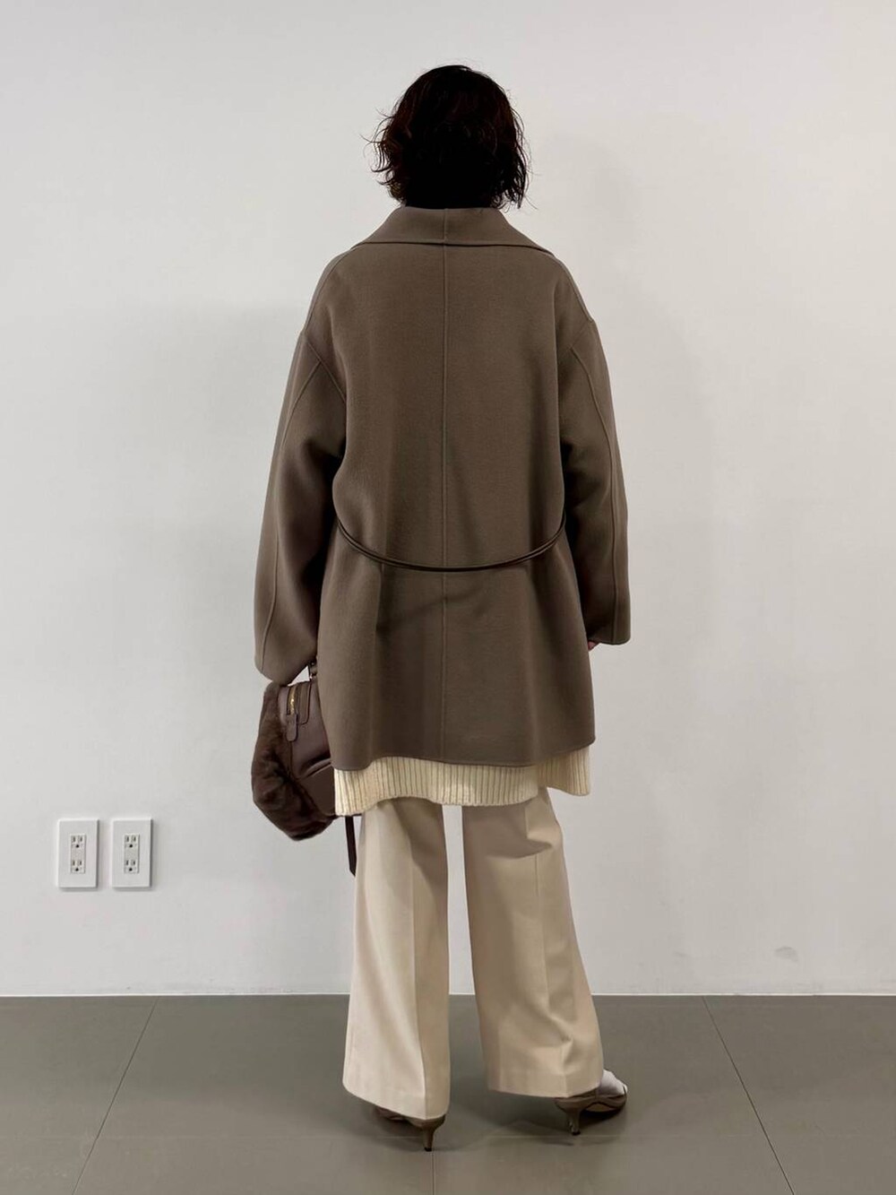 ベージュ系のその他パンツ、ベージュ系のハンドバッグ、ブラウン系のピーコートを着用したレディースの秋コーディネートの3枚目の写真