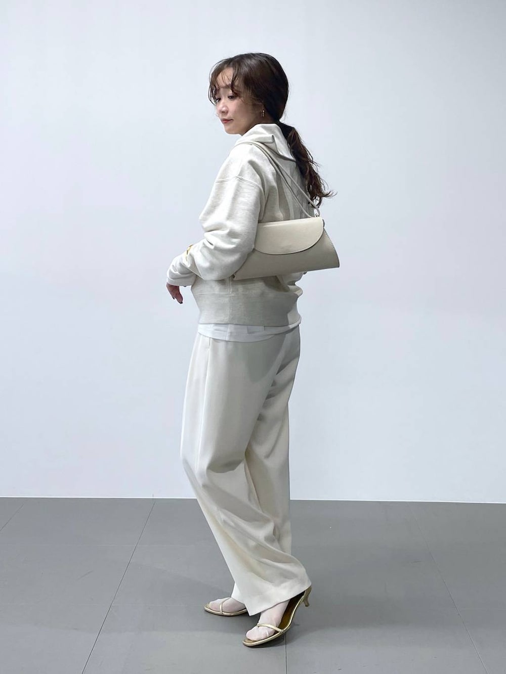 ホワイト系のショルダーバッグ、ホワイト系のTシャツ/カットソー、ホワイト系のスウェットを着用したレディースの冬コーディネートの3枚目の写真
