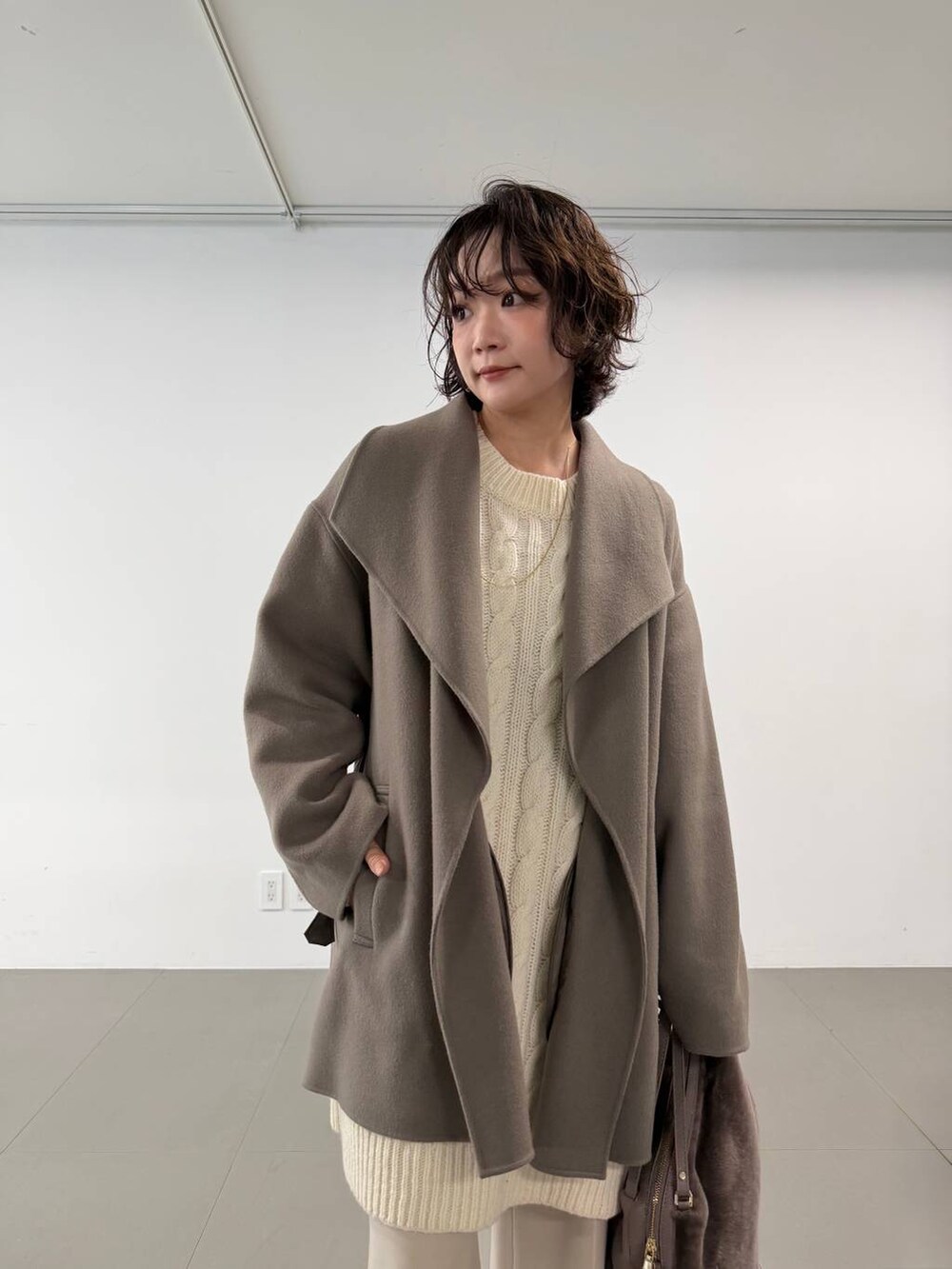 ベージュ系のその他パンツ、ベージュ系のハンドバッグ、ブラウン系のピーコートを着用したレディースの秋コーディネートの4枚目の写真