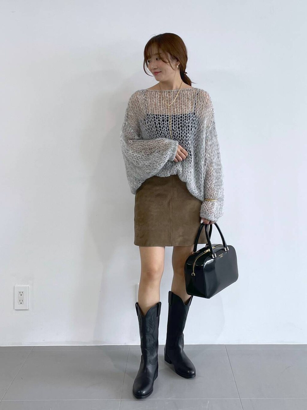 ブラック系のキャミソール、ブラック系のボストンバッグ、グレー系のニット/セーターを着用したレディースの夏コーディネートの2枚目の写真