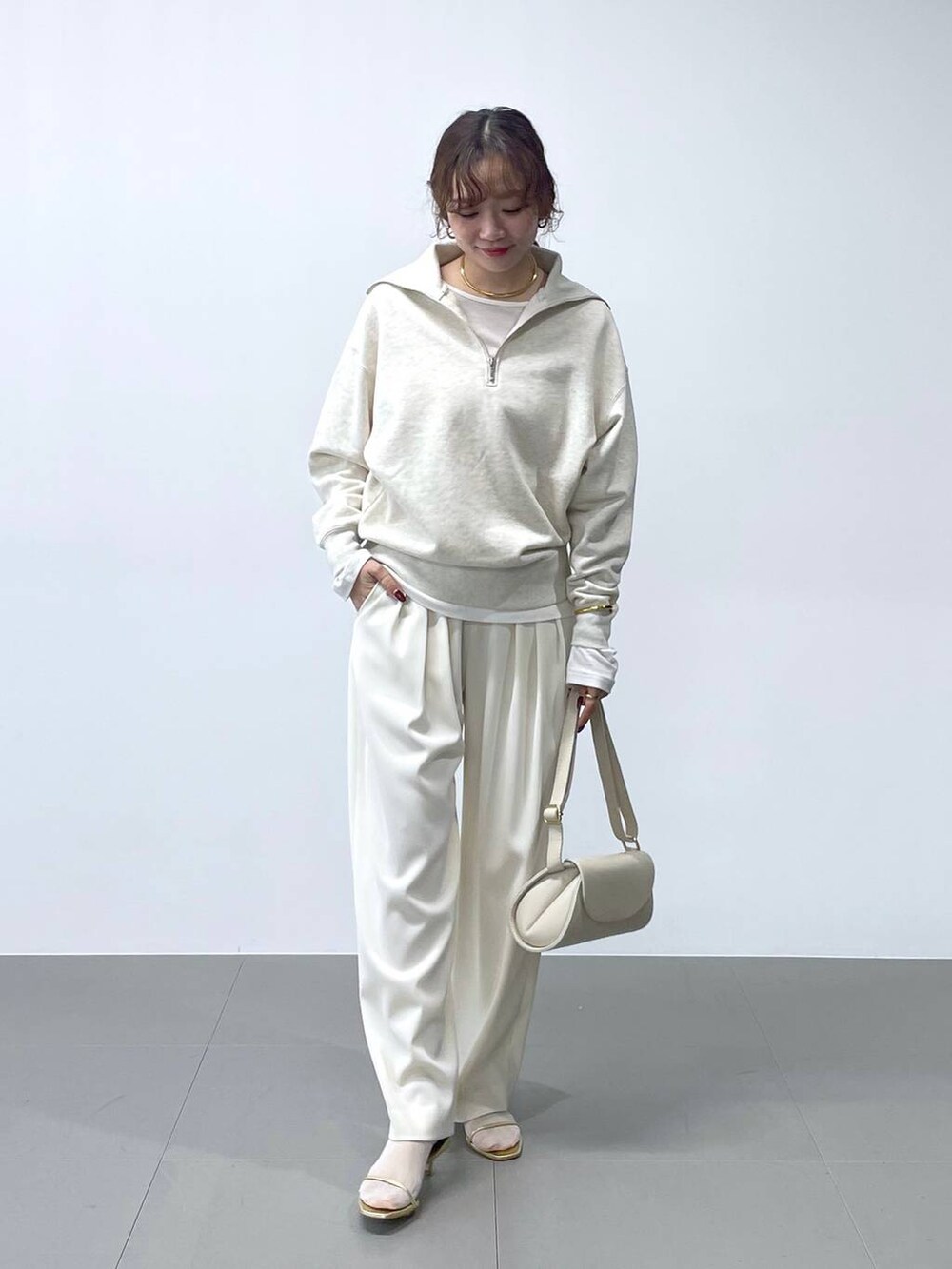 ホワイト系のショルダーバッグ、ホワイト系のTシャツ/カットソー、ホワイト系のスウェットを着用したレディースの冬コーディネートの2枚目の写真