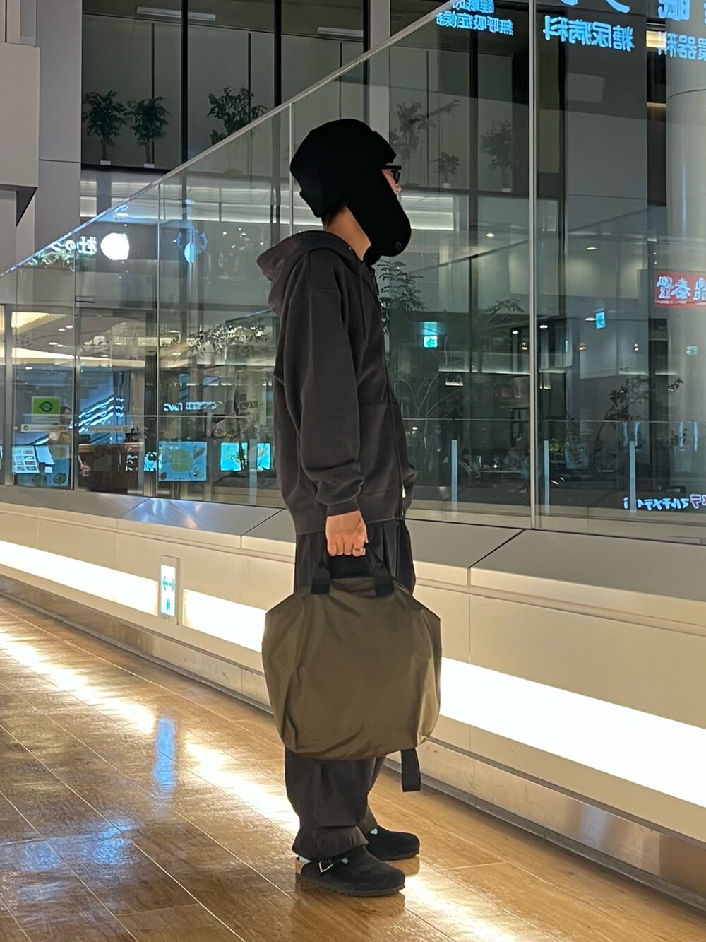 ブラック系のパーカー、ブラック系のその他パンツ、グリーン系のショルダーバッグを着用したメンズの秋コーディネートの2枚目の写真