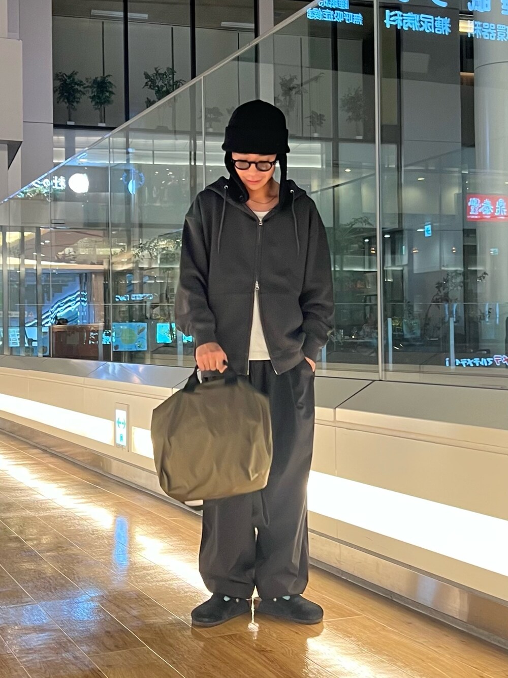 ブラック系のパーカー、ブラック系のその他パンツ、グリーン系のショルダーバッグを着用したメンズの秋コーディネートの4枚目の写真