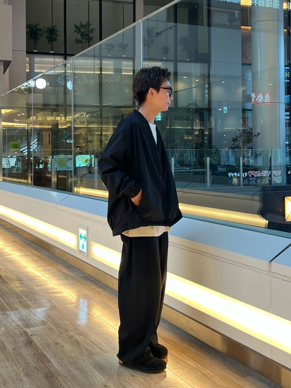 ブラック系のカーディガン/ボレロ、ベージュ系のTシャツ/カットソー、ブラック系のサンダルを着用したメンズの秋コーディネートの2枚目の写真