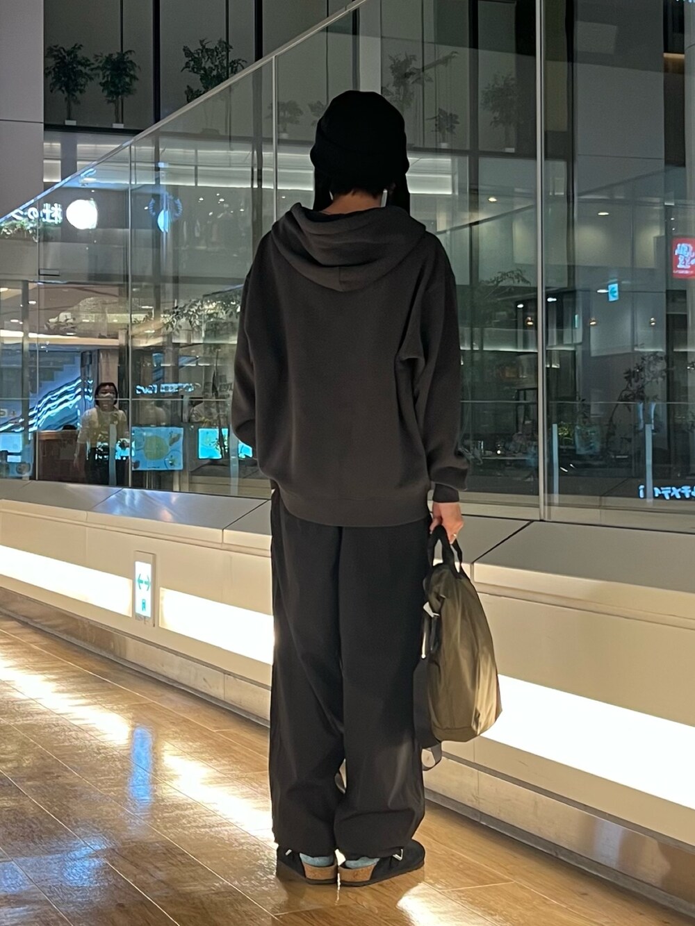 ブラック系のパーカー、ブラック系のその他パンツ、グリーン系のショルダーバッグを着用したメンズの秋コーディネートの3枚目の写真