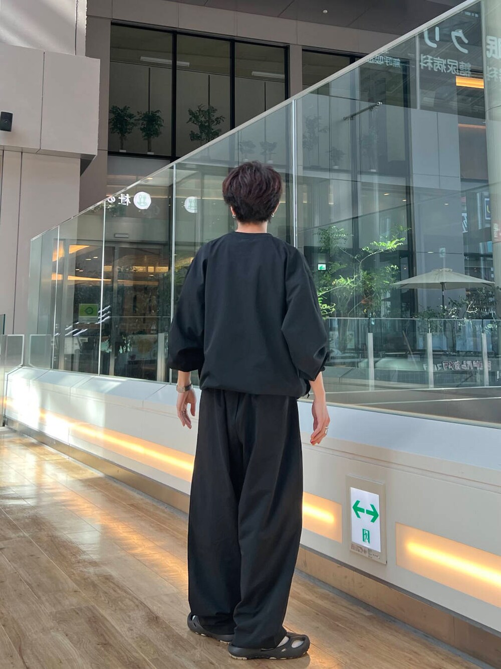 ブラック系のTシャツ/カットソー、ブラック系のその他パンツ、ブラック系のサンダルを着用したメンズの春コーディネートの3枚目の写真