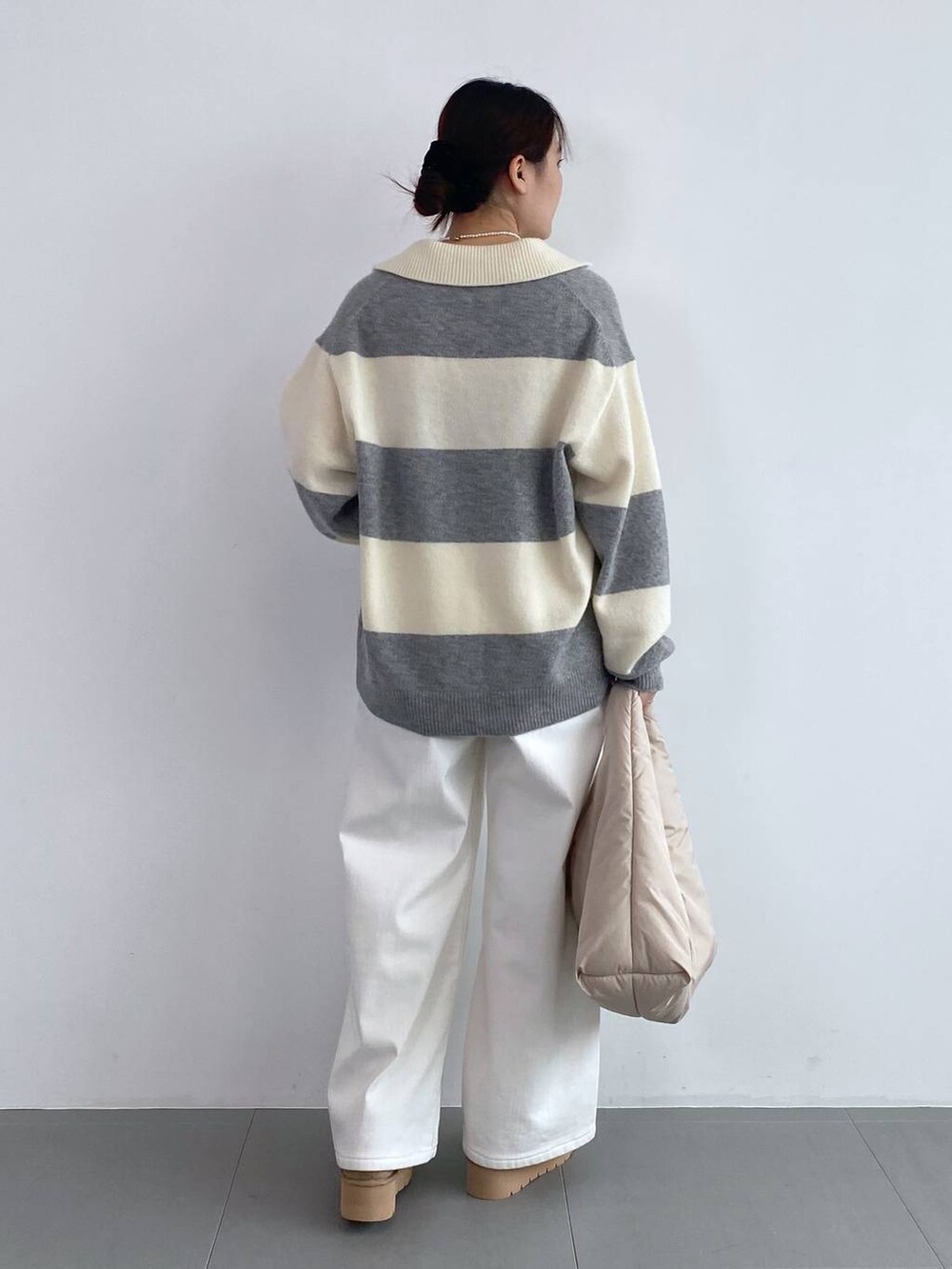 ホワイト系のデニムパンツ、ホワイト系のネックレスを着用したレディースの秋コーディネートの3枚目の写真