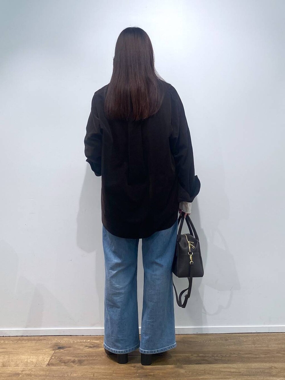 ブラウン系のボストンバッグ、ブルー系のデニムパンツ、ブラック系のシャツ/ブラウスを着用したレディースの夏コーディネートの4枚目の写真