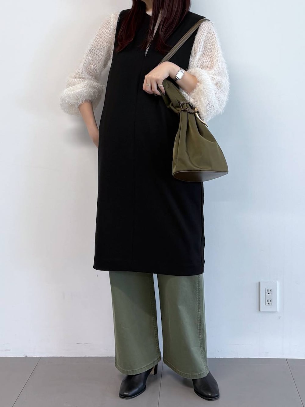 ブラック系のブーツ、グリーン系のその他パンツ、ホワイト系のシャツ/ブラウスを着用したレディースの冬コーディネートの2枚目の写真