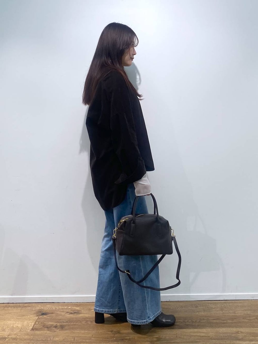 ブラウン系のボストンバッグ、ブルー系のデニムパンツ、ブラック系のシャツ/ブラウスを着用したレディースの夏コーディネートの3枚目の写真
