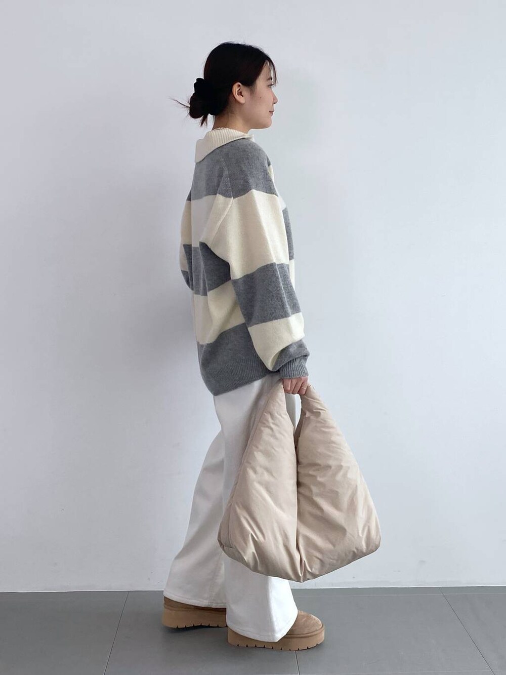 ホワイト系のデニムパンツ、ホワイト系のネックレスを着用したレディースの秋コーディネートの2枚目の写真