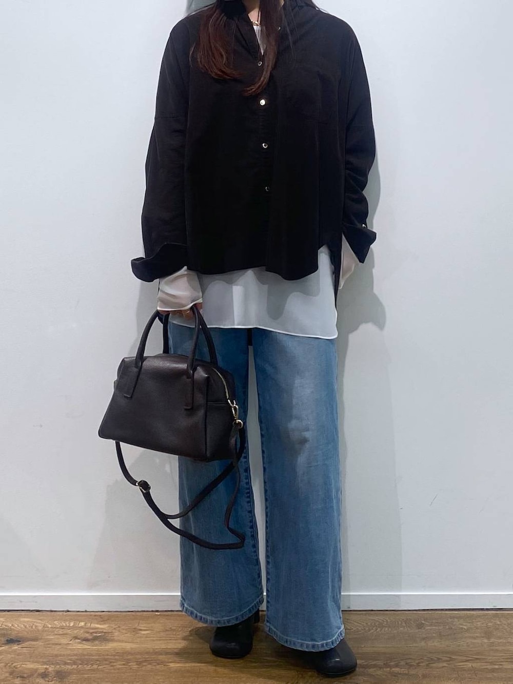 ブラウン系のボストンバッグ、ブルー系のデニムパンツ、ブラック系のシャツ/ブラウスを着用したレディースの夏コーディネートの2枚目の写真