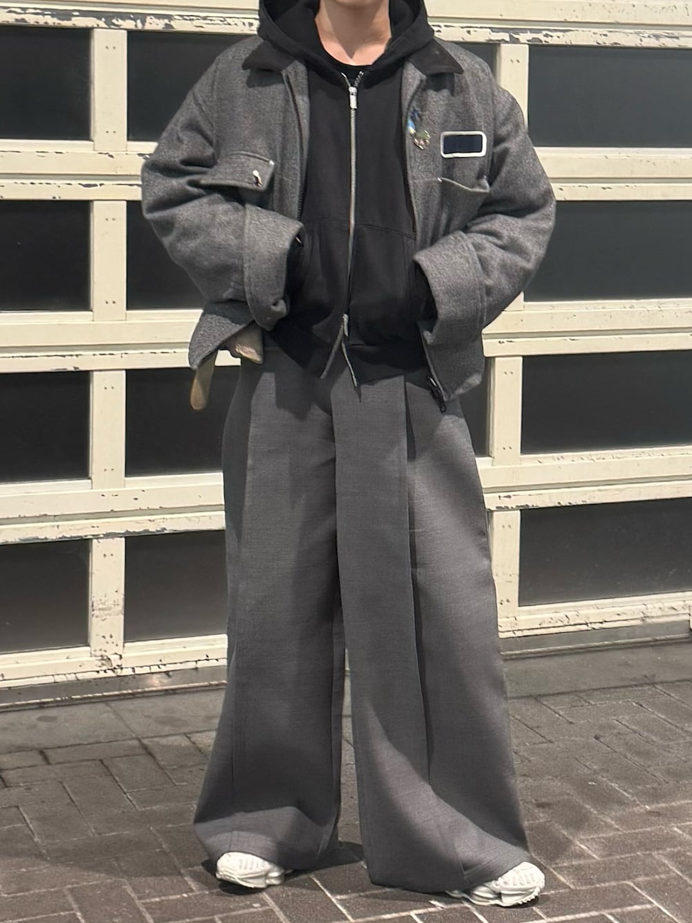 ブラック系のパーカー、グレー系のジャケット/アウター、グレー系のスラックスを着用したメンズの冬コーディネートの3枚目の写真