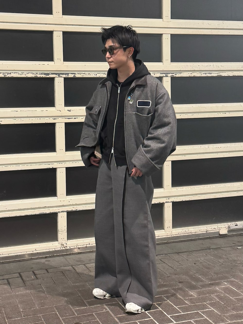 ブラック系のパーカー、グレー系のジャケット/アウター、グレー系のスラックスを着用したメンズの冬コーディネートの2枚目の写真