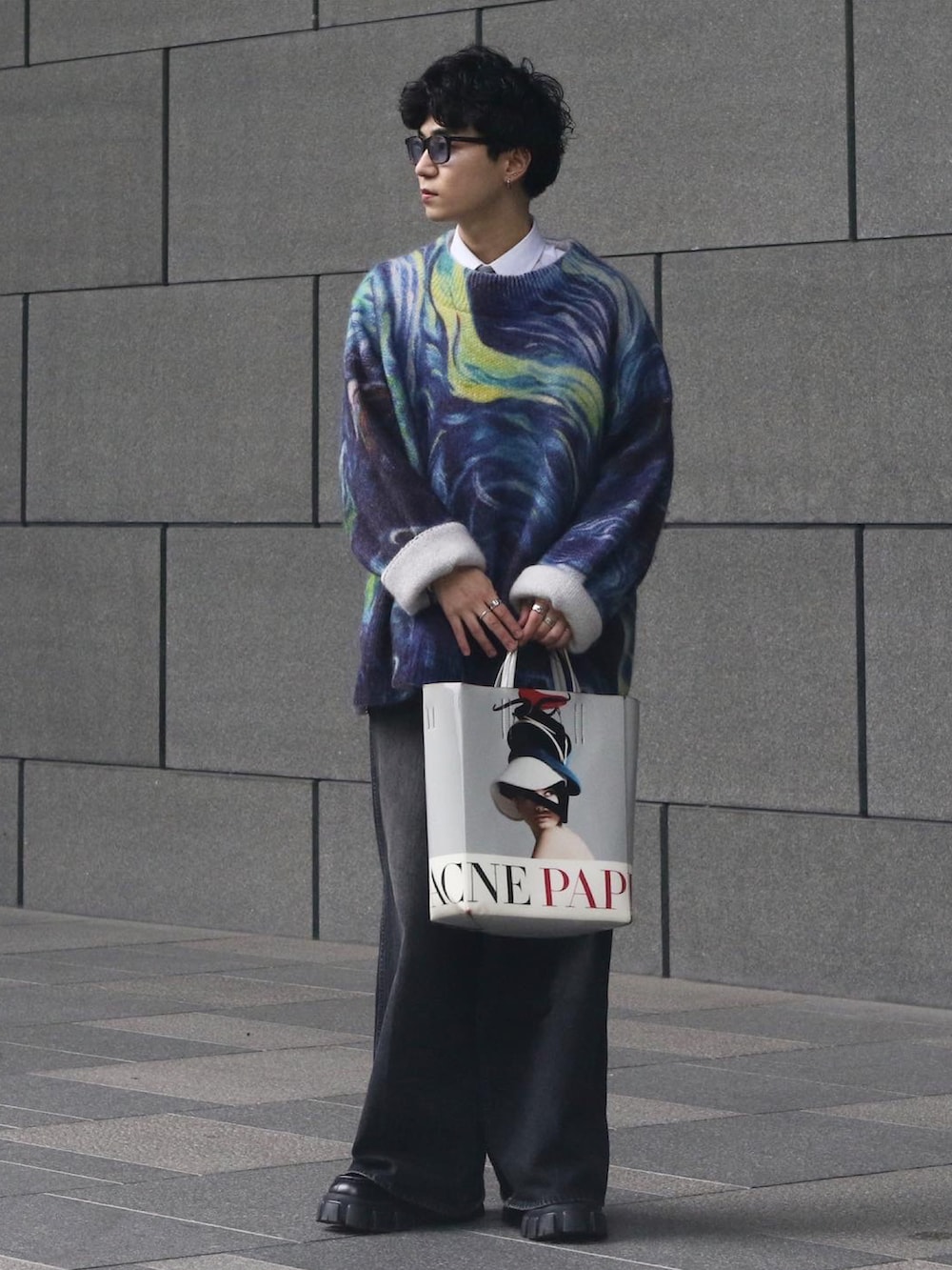 ブルー系のニット/セーター、ホワイト系のバッグ、ブラック系のローファーを着用したメンズの春コーディネートの3枚目の写真