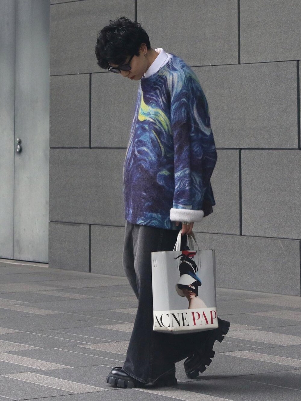 ブルー系のニット/セーター、ホワイト系のバッグ、ブラック系のローファーを着用したメンズの春コーディネートの4枚目の写真