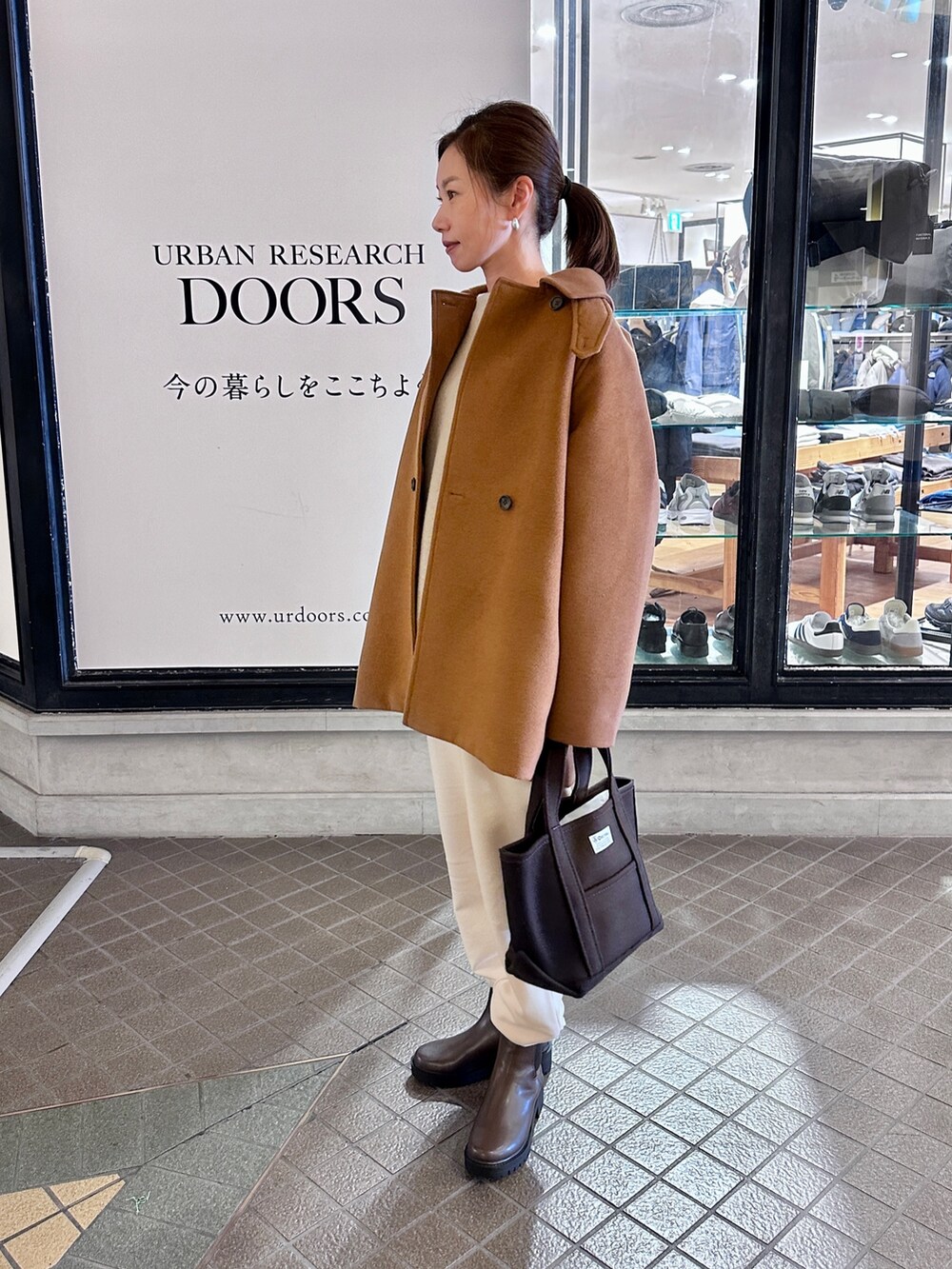 ブラウン系のブーツ、ブラウン系のトートバッグ、ベージュ系のニット/セーターを着用したレディースの秋コーディネートの2枚目の写真