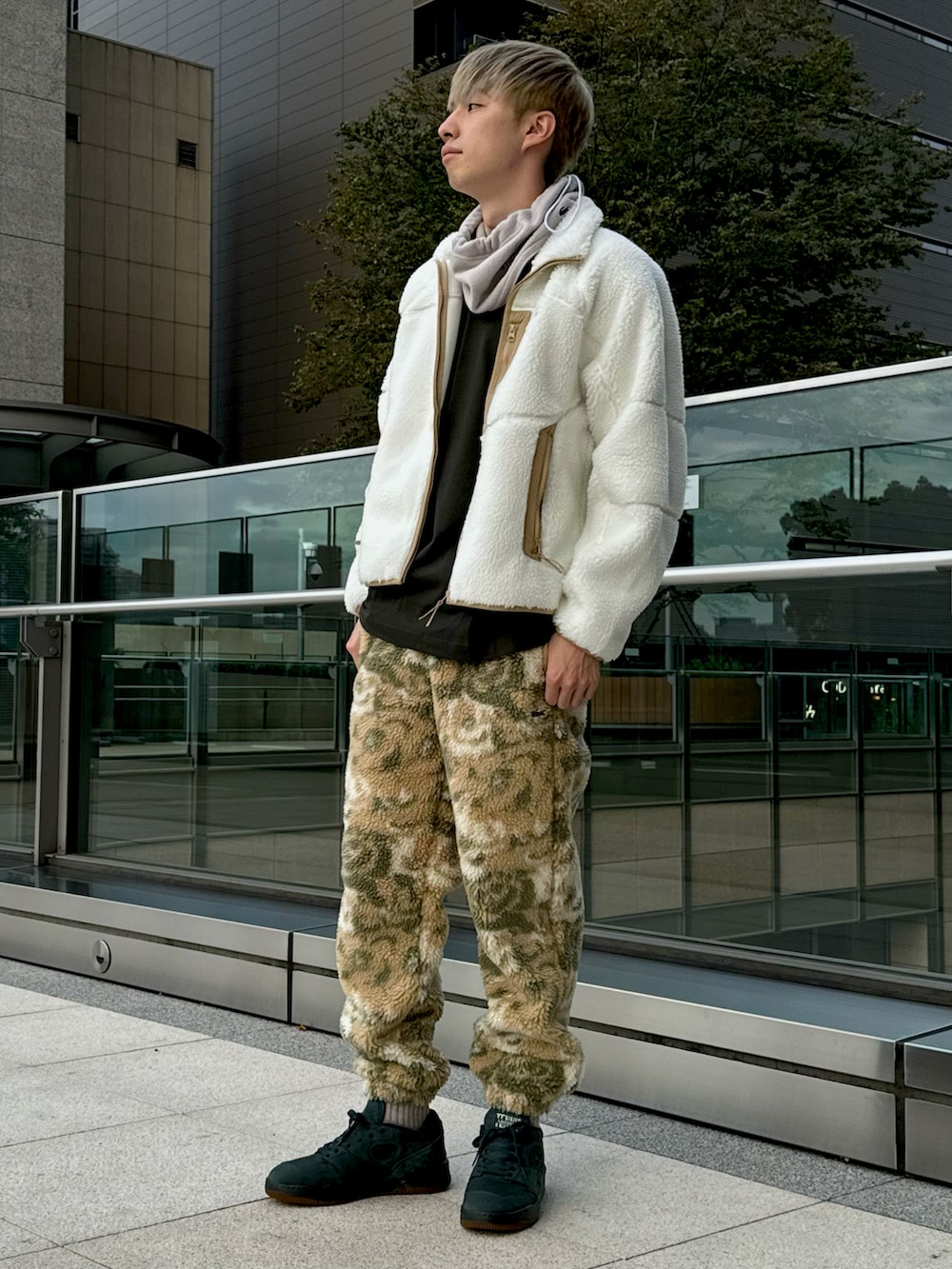 ホワイト系のブルゾン、ベージュ系のスウェットパンツ、グリーン系のスニーカーを着用したメンズの冬コーディネートの2枚目の写真