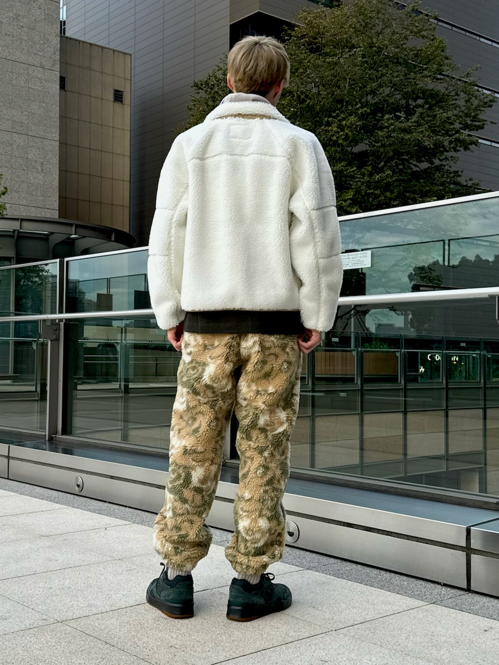 ホワイト系のブルゾン、ベージュ系のスウェットパンツ、グリーン系のスニーカーを着用したメンズの冬コーディネートの3枚目の写真