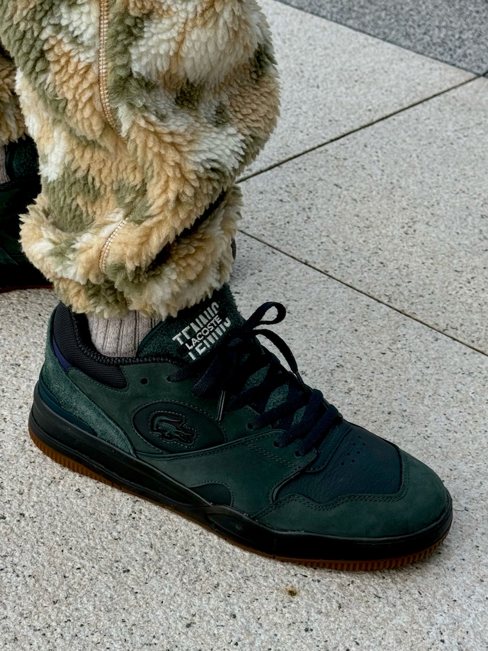 ホワイト系のブルゾン、ベージュ系のスウェットパンツ、グリーン系のスニーカーを着用したメンズの冬コーディネートの5枚目の写真