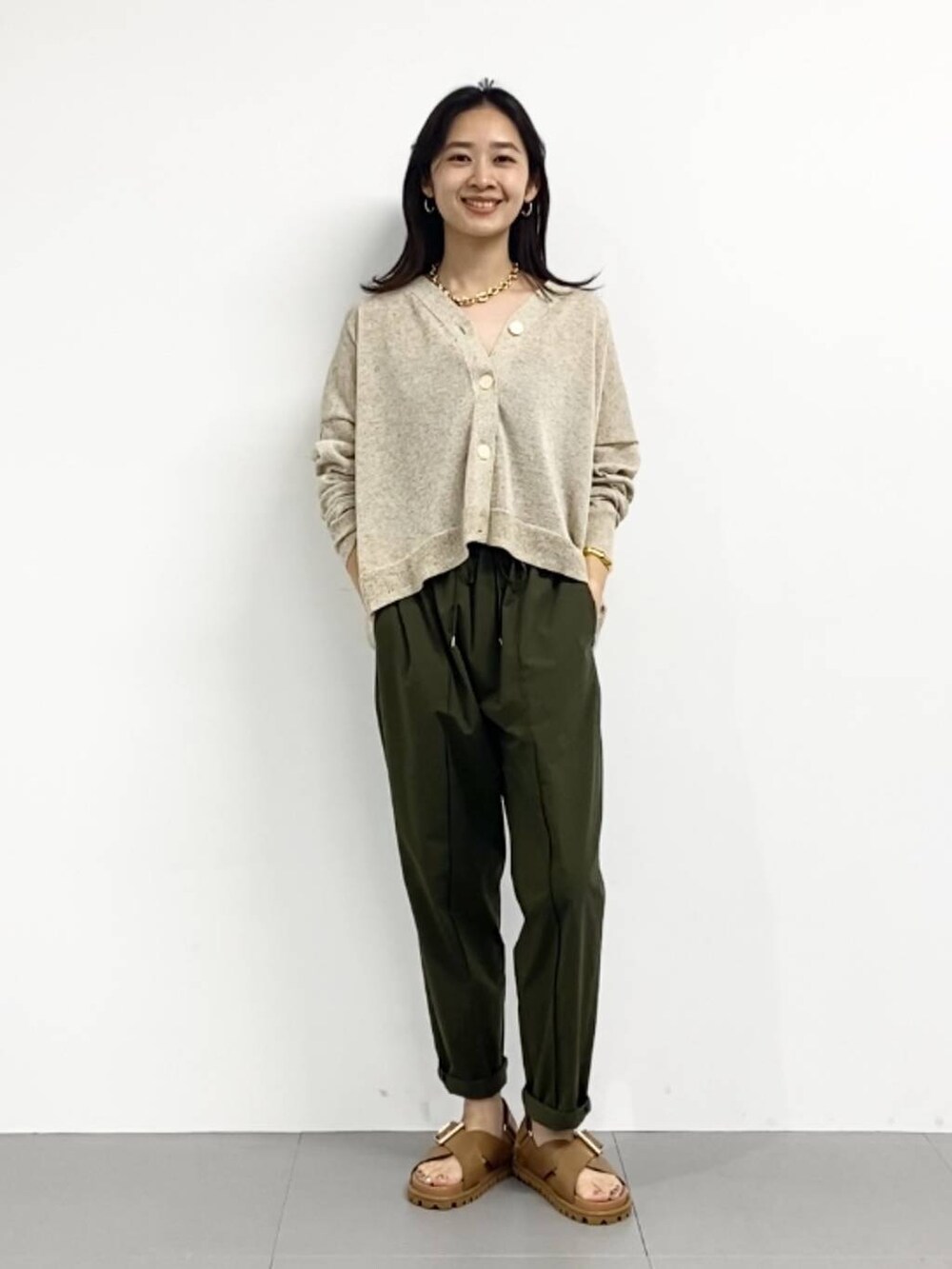 イエロー系のサンダル、グリーン系のその他パンツ、ベージュ系のカーディガン/ボレロを着用したレディースの春コーディネートの2枚目の写真