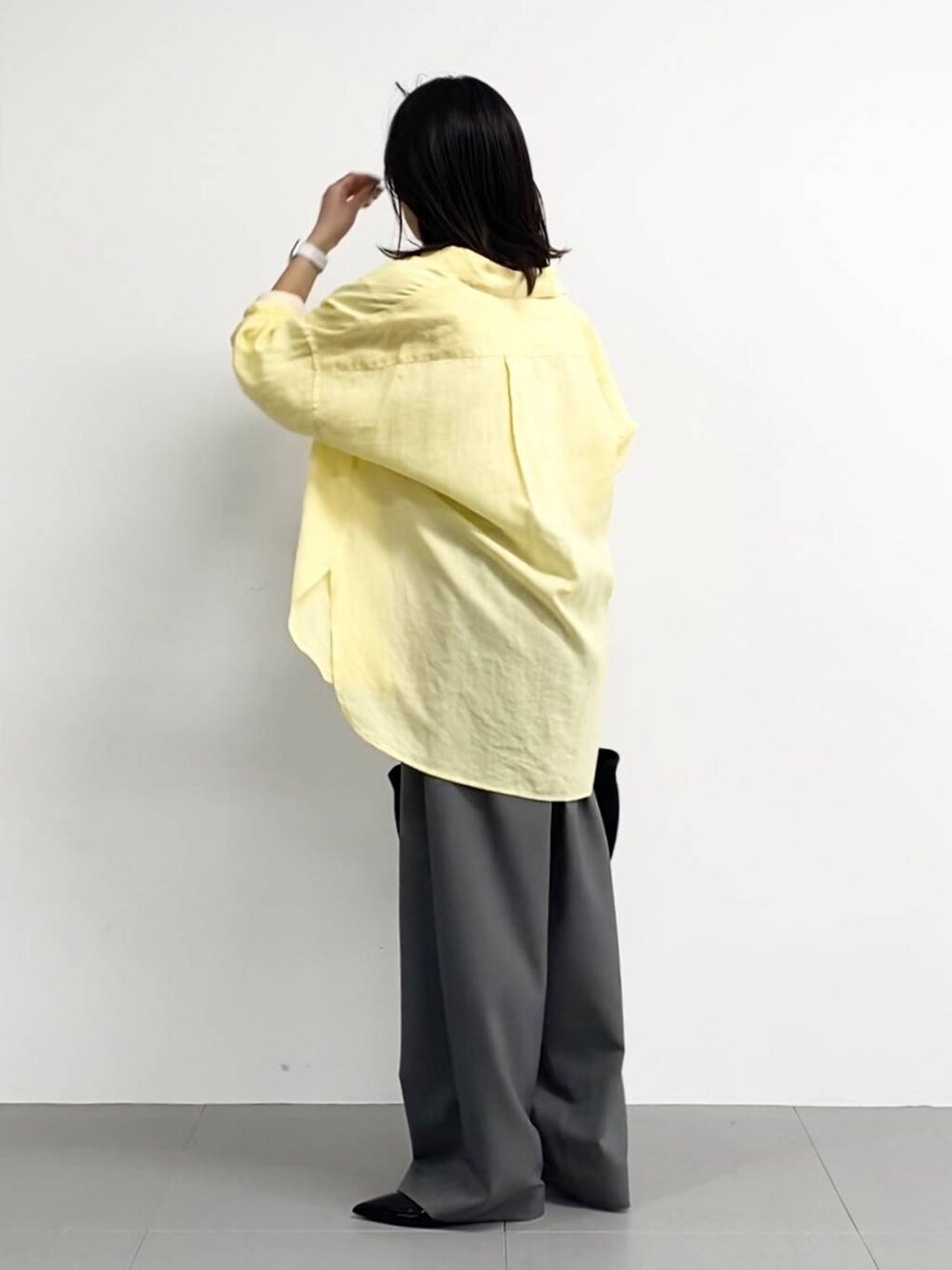 ブラック系のトートバッグ、ホワイト系のTシャツ/カットソー、ブラック系のパンプスを着用したレディースの春コーディネートの4枚目の写真