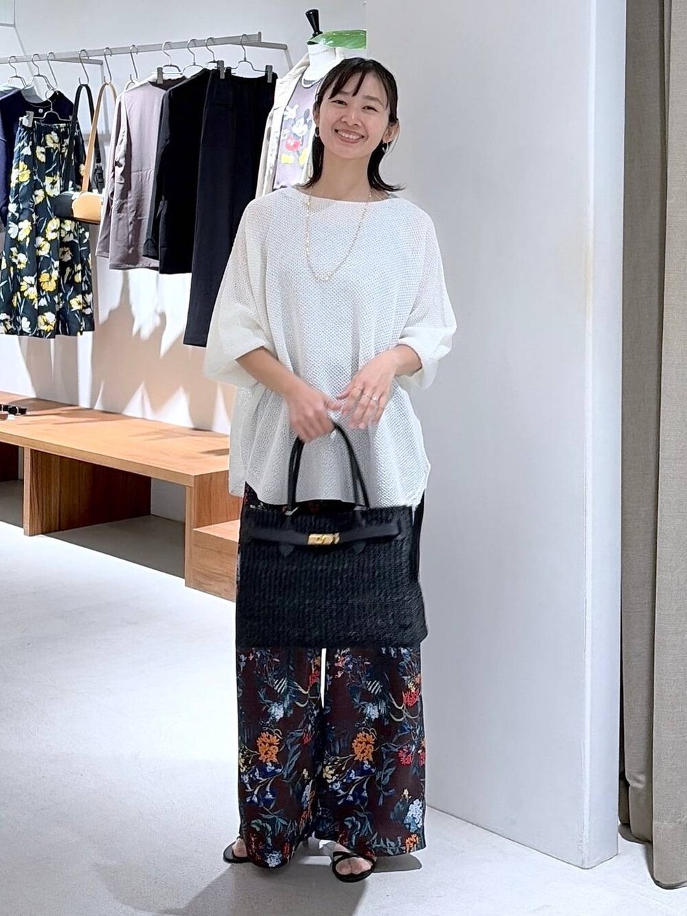 ホワイト系のニット/セーター、ブラウン系のその他パンツ、ブラック系のかごバッグを着用したレディースの春コーディネートの3枚目の写真