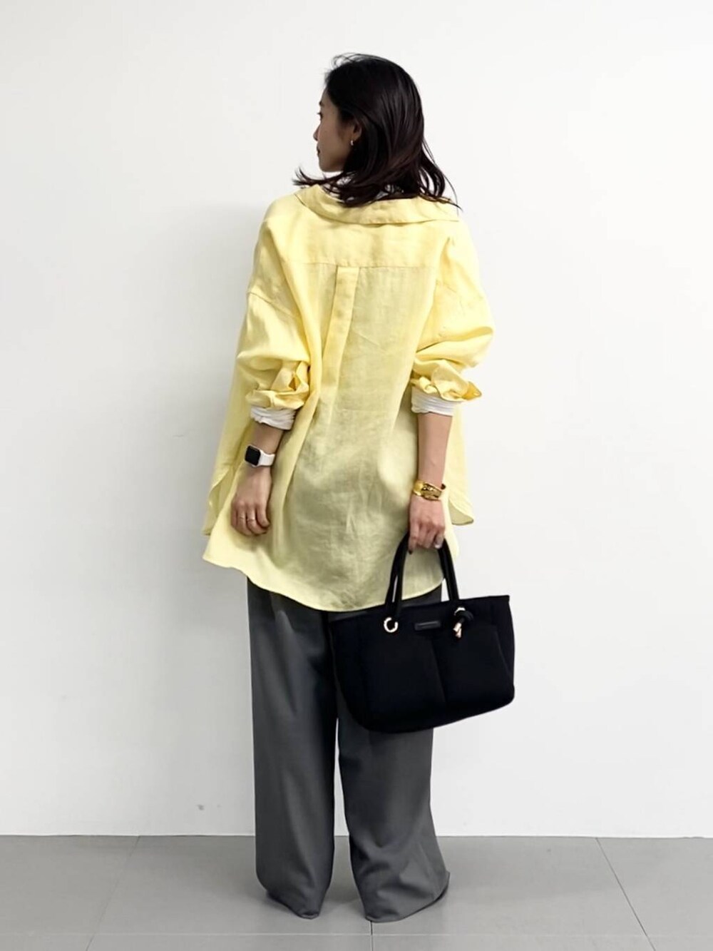 ブラック系のトートバッグ、ホワイト系のTシャツ/カットソー、ブラック系のパンプスを着用したレディースの春コーディネートの5枚目の写真