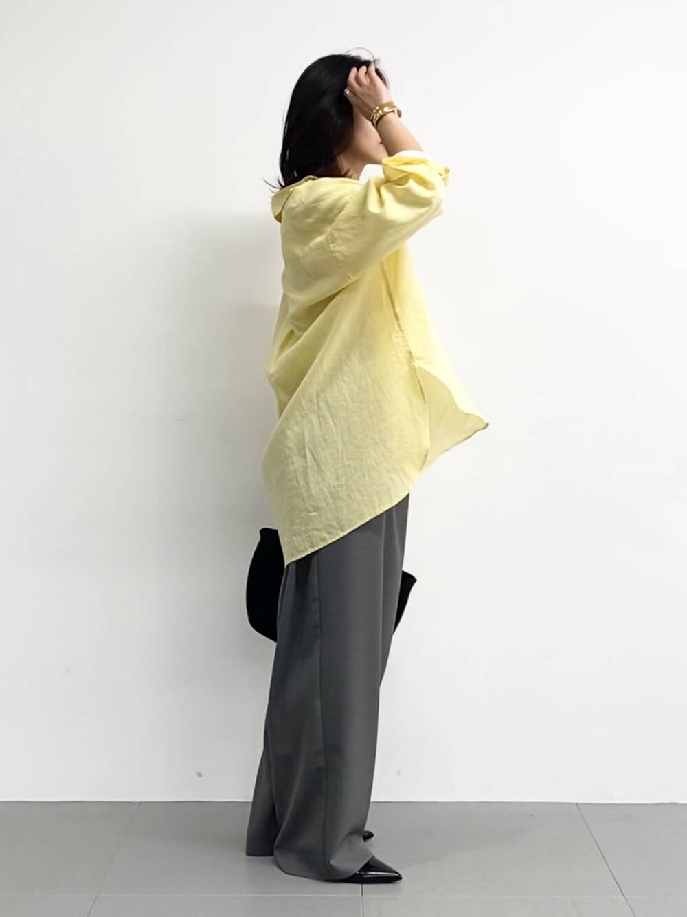 ブラック系のトートバッグ、ホワイト系のTシャツ/カットソー、ブラック系のパンプスを着用したレディースの春コーディネートの6枚目の写真