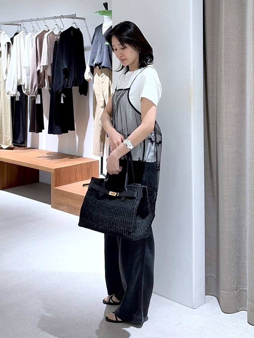 グレー系のデニムパンツ、ブラック系のサンダル、ブラック系のキャミソールを着用したレディースの春コーディネートの2枚目の写真