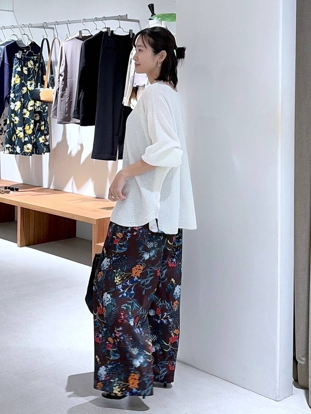 ホワイト系のニット/セーター、ブラウン系のその他パンツ、ブラック系のかごバッグを着用したレディースの春コーディネートの4枚目の写真