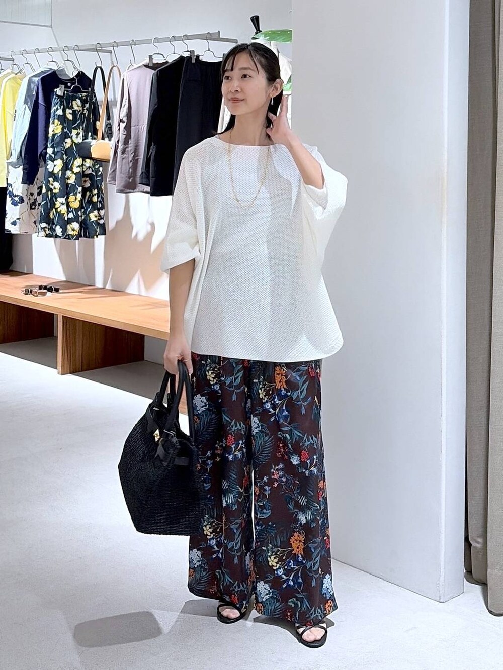 ホワイト系のニット/セーター、ブラウン系のその他パンツ、ブラック系のかごバッグを着用したレディースの春コーディネートの6枚目の写真