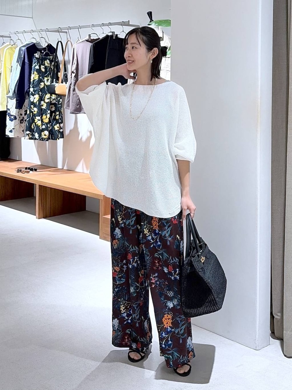 ホワイト系のニット/セーター、ブラウン系のその他パンツ、ブラック系のかごバッグを着用したレディースの春コーディネートの2枚目の写真