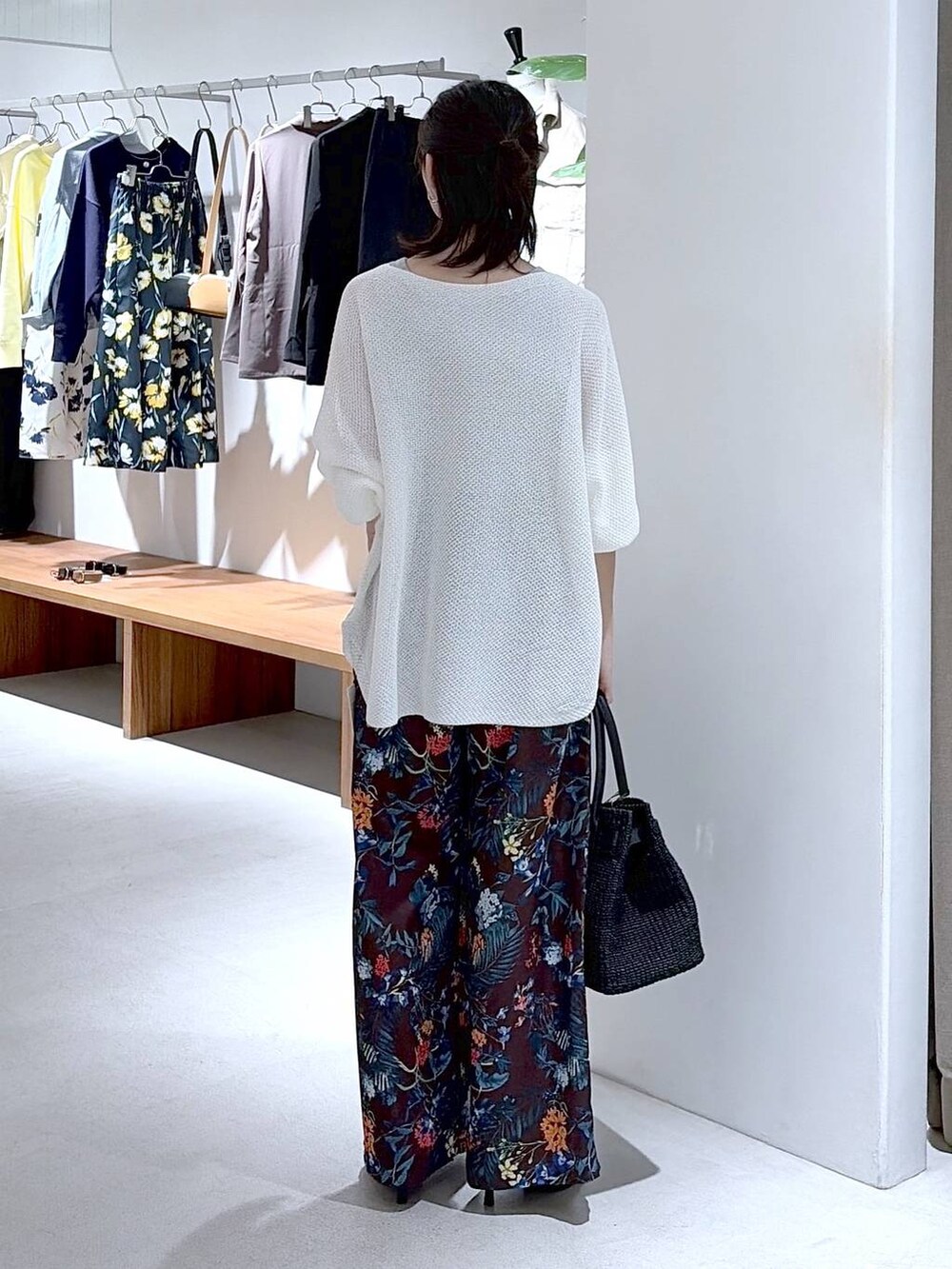 ホワイト系のニット/セーター、ブラウン系のその他パンツ、ブラック系のかごバッグを着用したレディースの春コーディネートの5枚目の写真