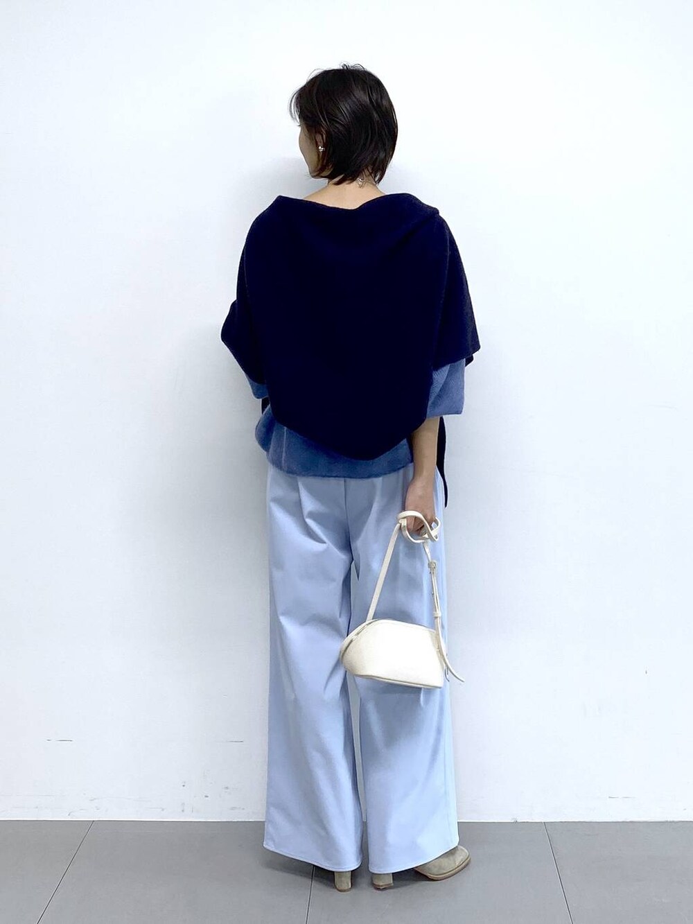 ホワイト系のショルダーバッグ、ベージュ系のブーツ、ブルー系のその他パンツを着用したレディースの秋コーディネートの4枚目の写真