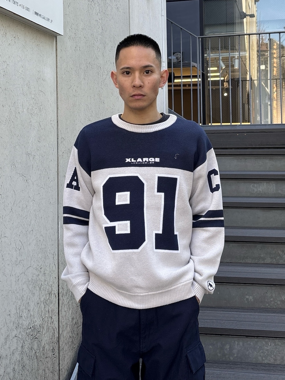 オレンジ系のニット/セーター、ブルー系のカーゴパンツを着用したメンズの冬コーディネートの5枚目の写真