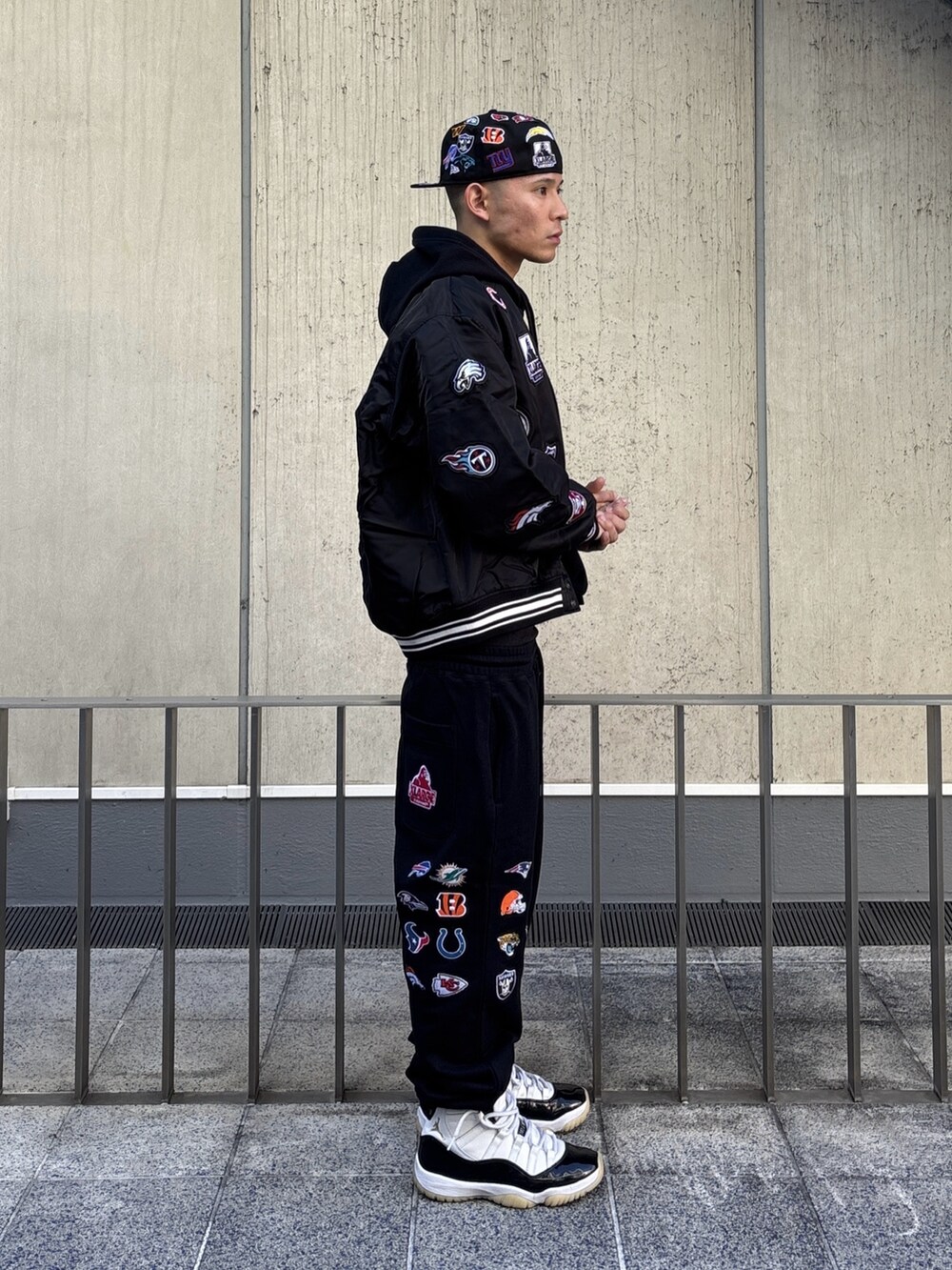 ブラック系のブルゾン、ブラック系のパーカー、ブラック系のスウェットパンツを着用したメンズの冬コーディネートの3枚目の写真