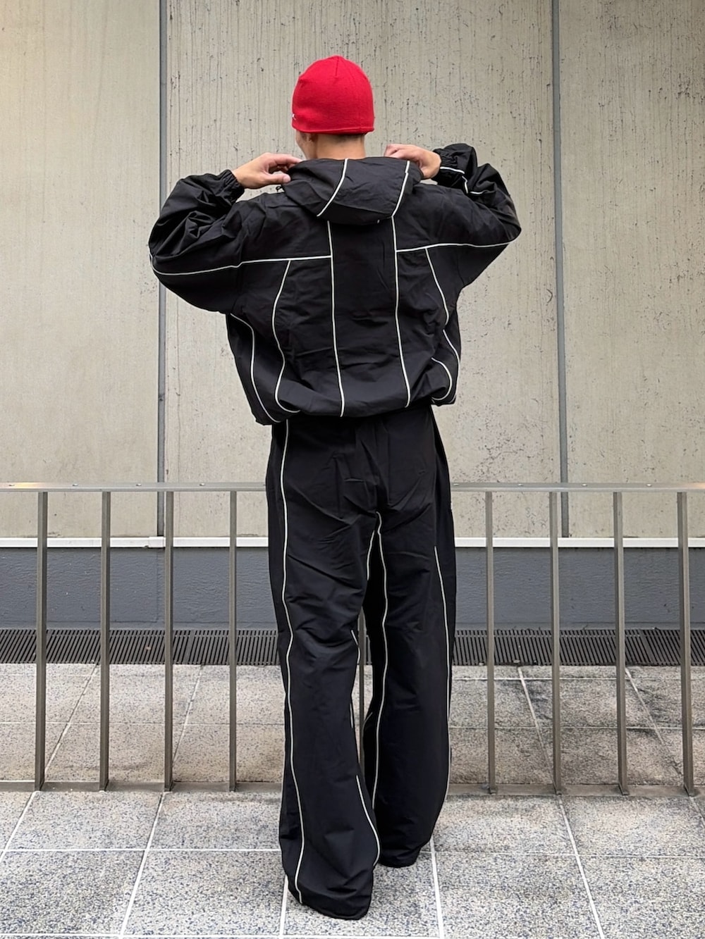 ブラック系のブルゾン、ブラック系のその他パンツ、レッド系のニットキャップ/ビーニーを着用したメンズの秋コーディネートの4枚目の写真