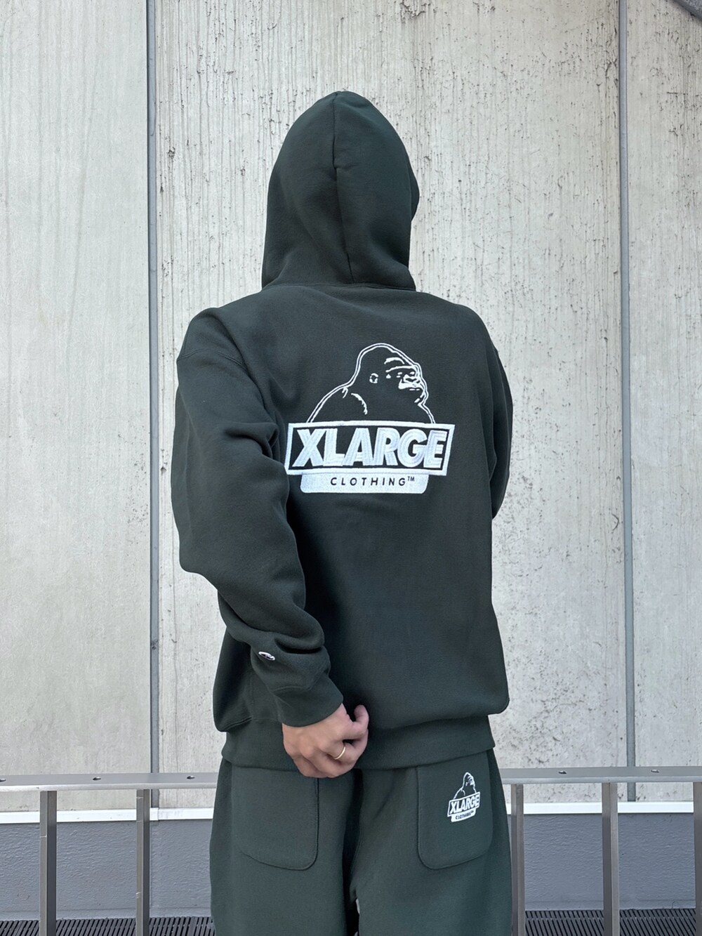 グリーン系のパーカー、グリーン系のスウェットパンツ、ブラック系のキャップを着用したメンズの秋コーディネートの8枚目の写真