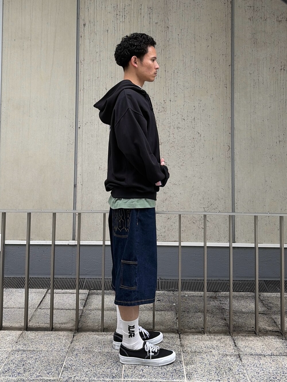 ブラウン系のパーカー、ブルー系のデニムパンツを着用したメンズの春コーディネートの3枚目の写真
