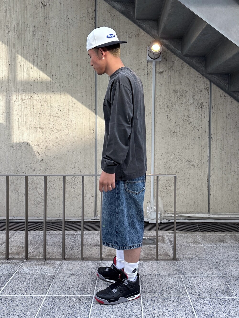 ブラック系のTシャツ/カットソー、ブルー系のその他パンツ、ホワイト系のキャップを着用したメンズの春コーディネートの2枚目の写真