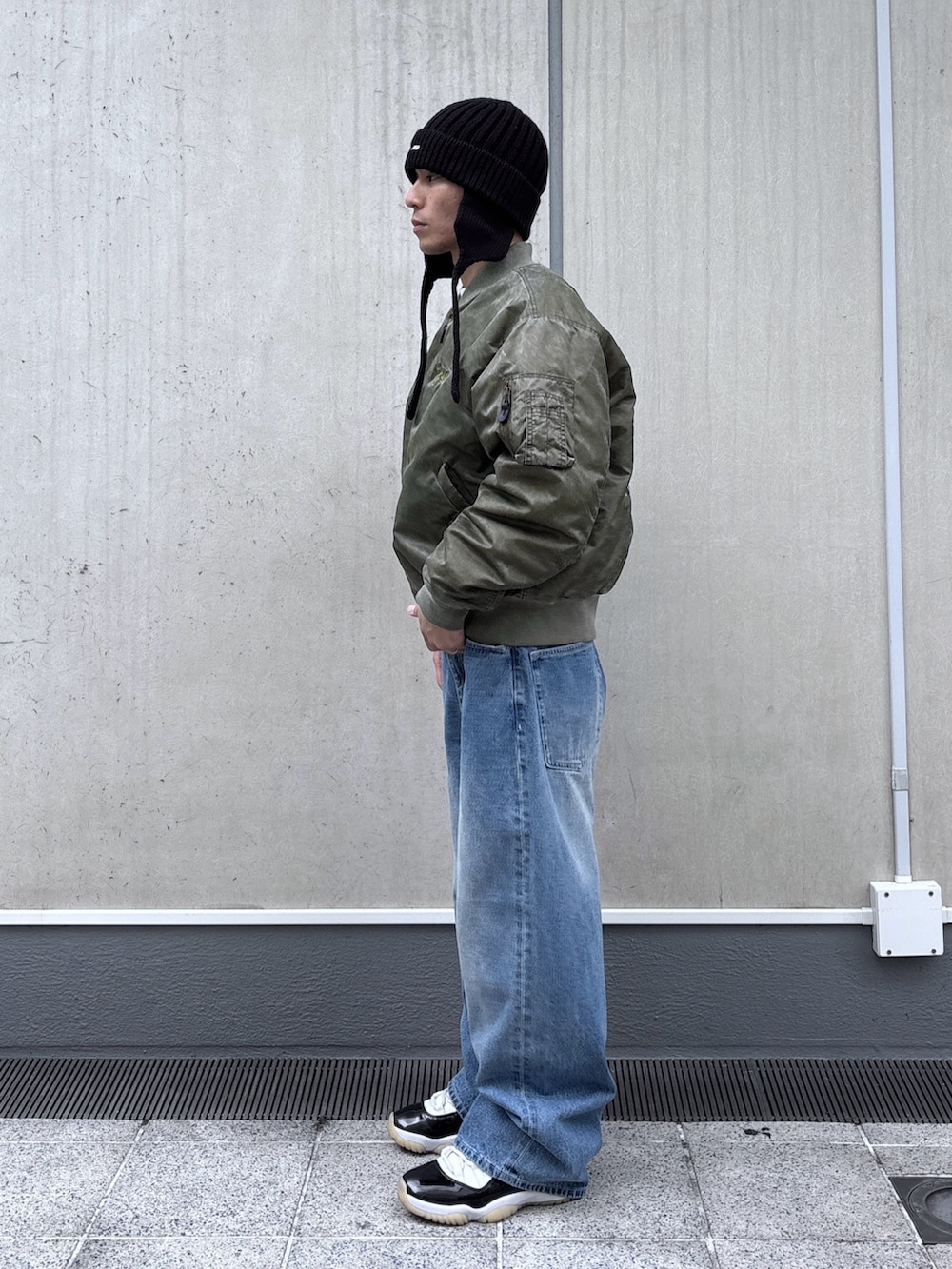 ブラック系のMA-1、ブルー系のデニムパンツ、ブラック系のニットキャップ/ビーニーを着用したメンズの秋コーディネートの2枚目の写真