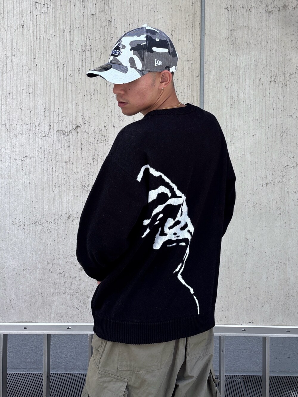 ブラック系のニット/セーター、グリーン系のカーゴパンツ、その他のキャップを着用したメンズの秋コーディネートの9枚目の写真