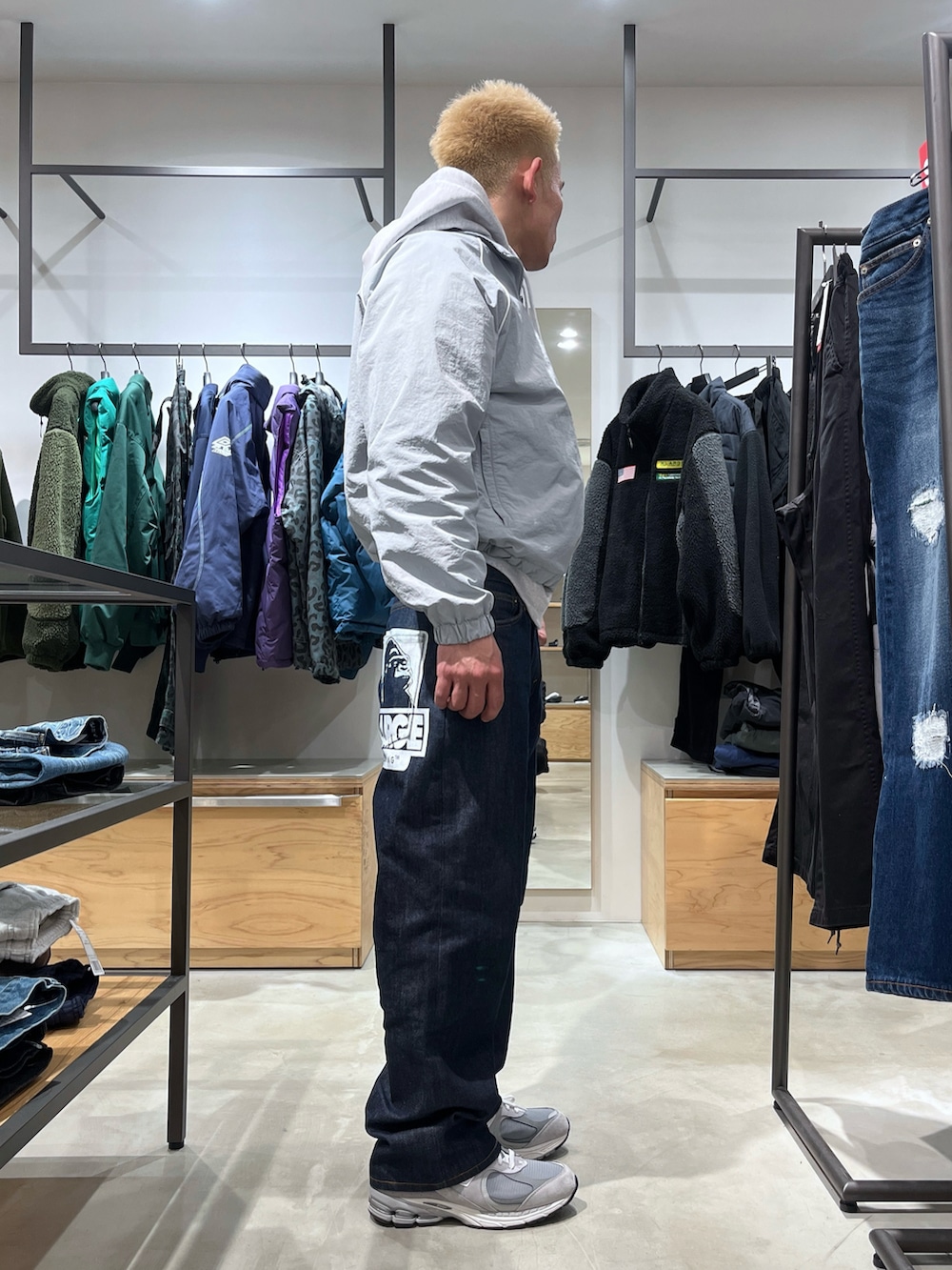 グレー系のナイロンジャケット、ブルー系のデニムパンツを着用したメンズの冬コーディネートの3枚目の写真