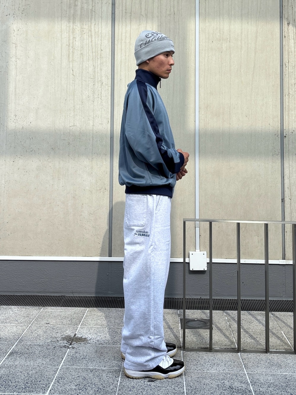 グレー系のスウェットパンツ、ブルー系のブルゾン、ブラック系のニットキャップ/ビーニーを着用したメンズの秋コーディネートの4枚目の写真