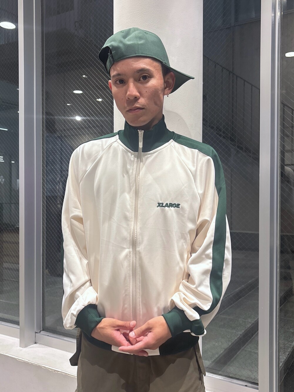 ホワイト系のブルゾン、グリーン系のカーゴパンツ、グリーン系のキャップを着用したメンズの秋コーディネートの5枚目の写真