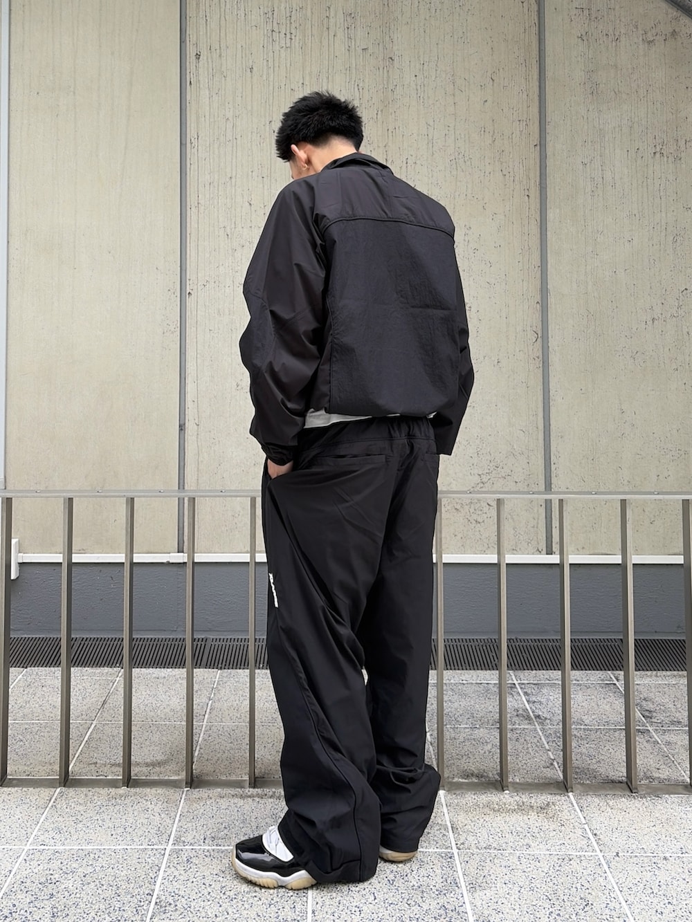 ブラック系のナイロンジャケット、ブラック系のその他パンツを着用したメンズの春コーディネートの4枚目の写真