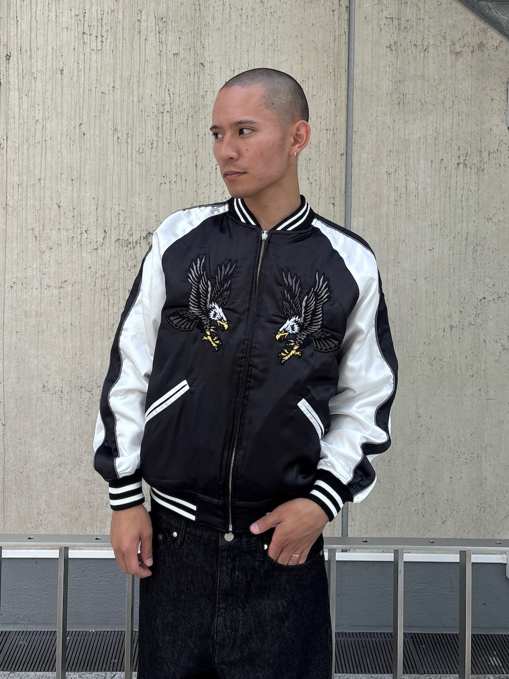 ブラック系のスカジャン、ブラック系のデニムパンツを着用したメンズの秋コーディネートの7枚目の写真